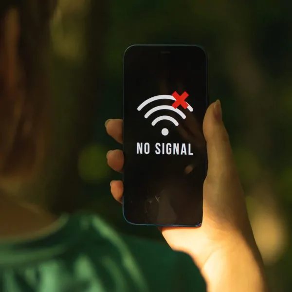 Mobile phone without signal, no service screen, girl in the forest with smartphone, searching for the help concept photo